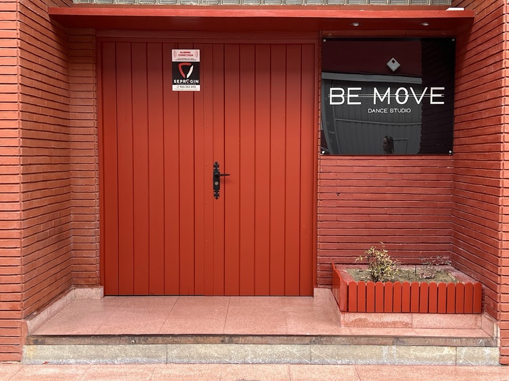 Entrada de Be Move Dance Studio: puerta de madera y rótulo con el nombre de la escuela